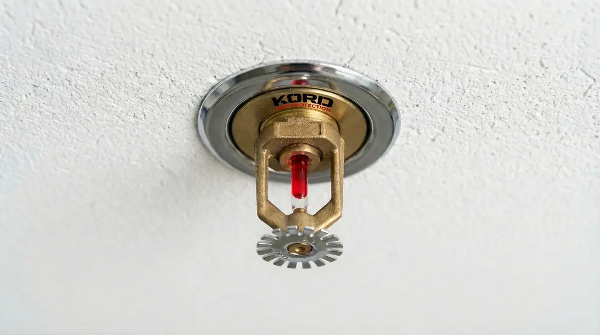 Close-up of a fire sprinkler head showing temperature rating bulb