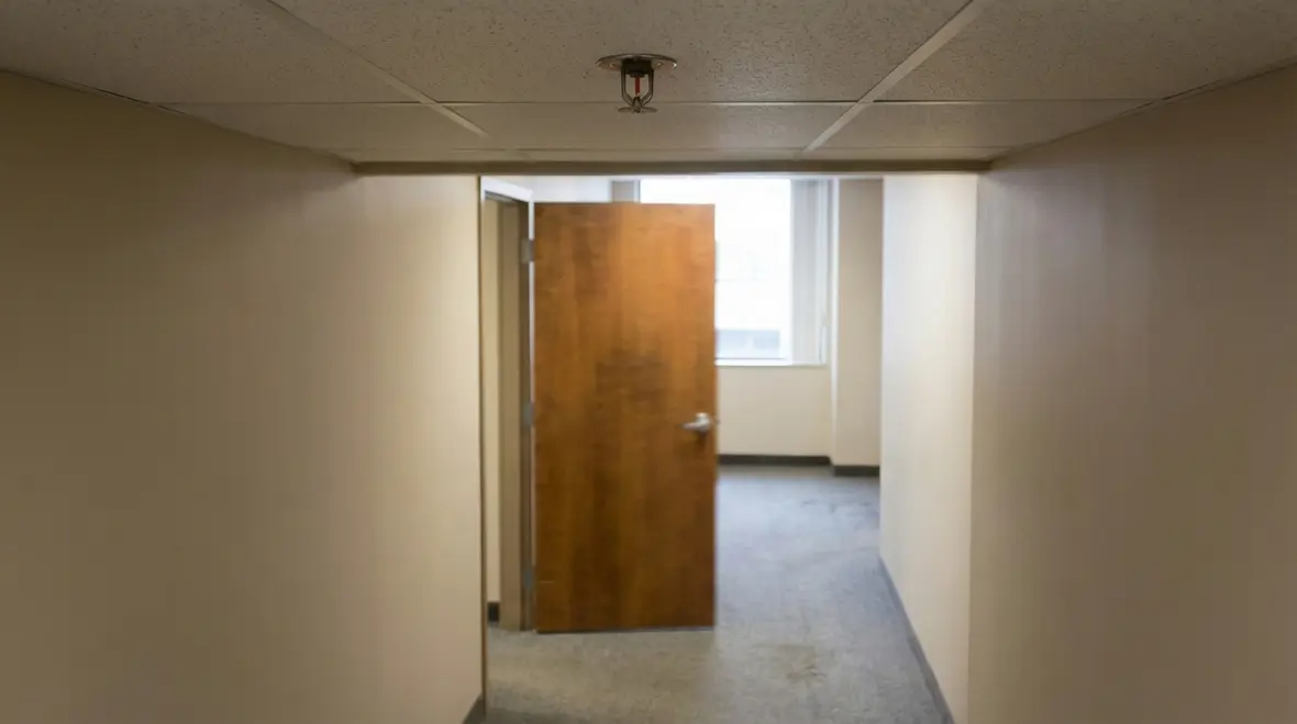 Interior hallway with fire sprinkler and door showing proper spacing