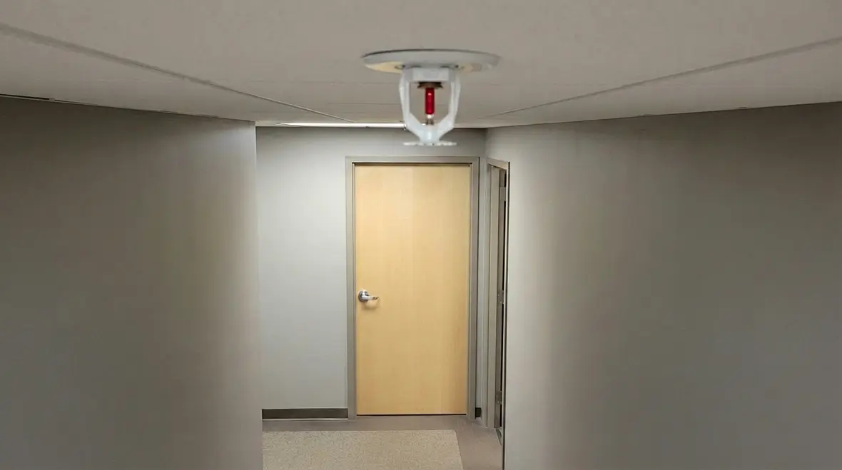 Fire sprinkler head near a door showing safe clearance
