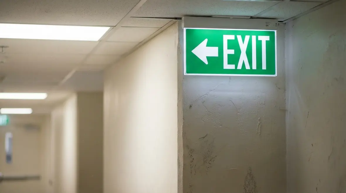 Illuminated exit sign leading toward emergency egress path