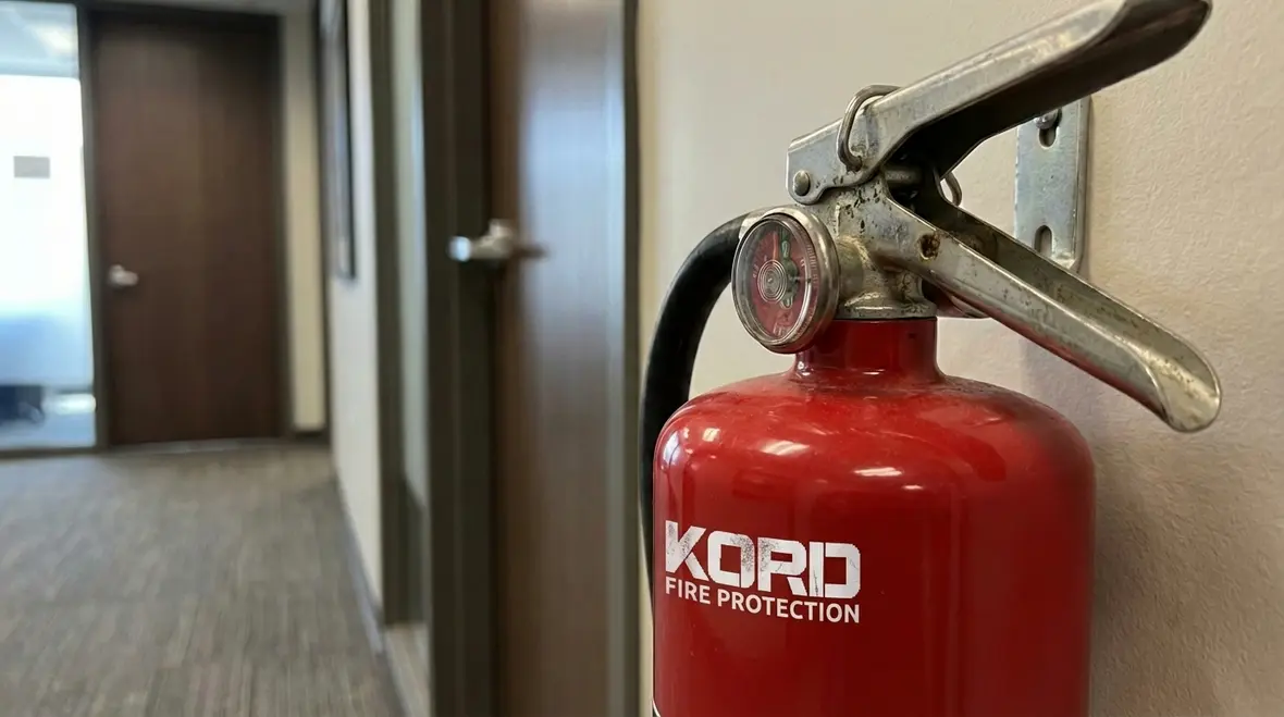 Fire extinguisher labeled 2A 10B C hanging on a commercial wall
