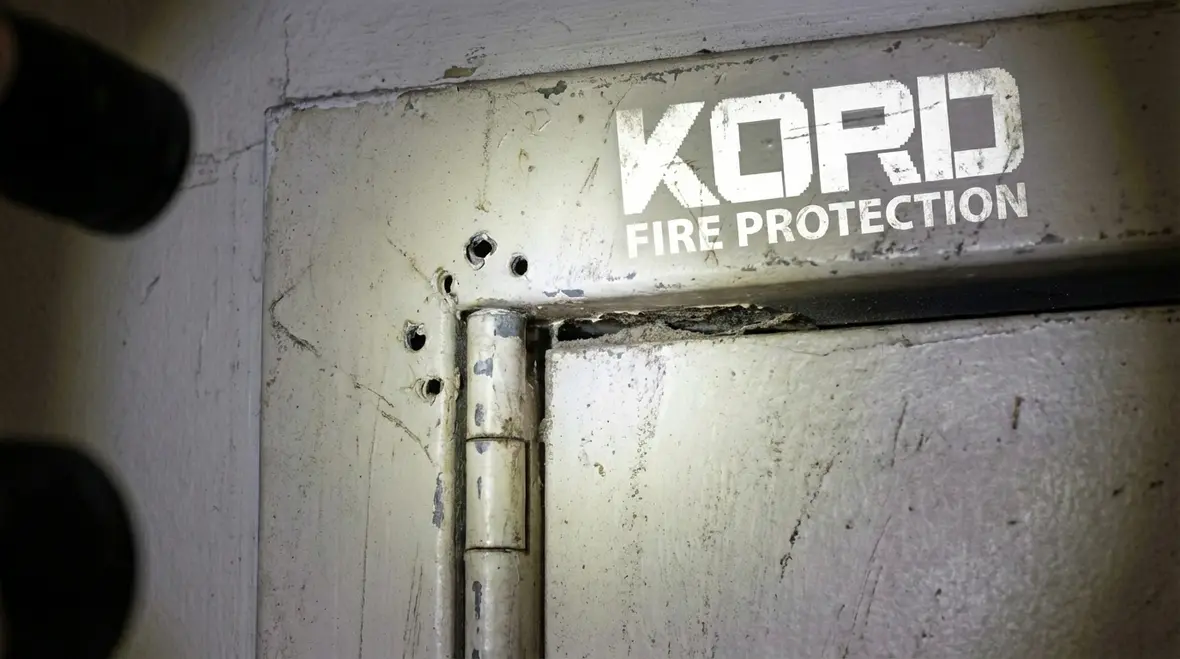 Inspector measuring fire door gap clearance