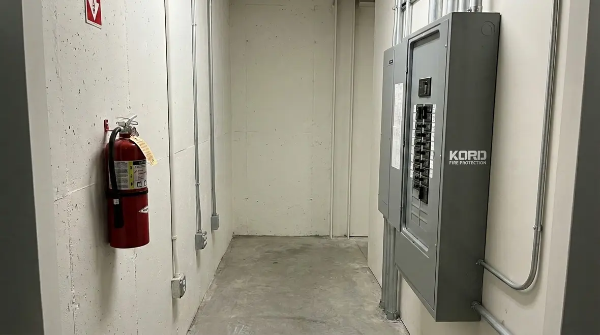 Fire extinguisher mounted safely near an electrical panel