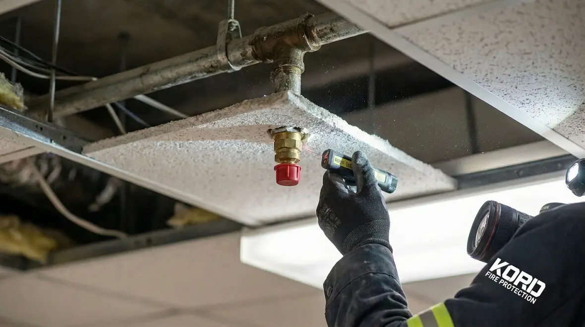 Fire suppression nozzle inspection technician checking nozzle cap and alignment