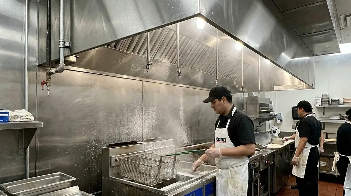 Grease fire suppression system protecting a commercial kitchen cooking line