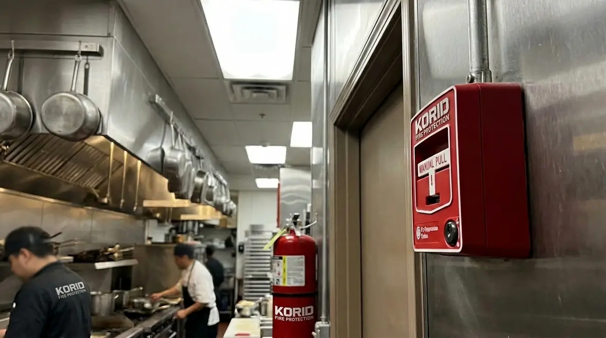 Kitchen suppression pull station installed near a commercial kitchen exit